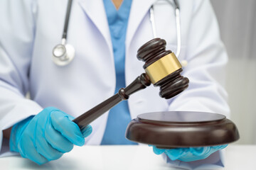 Asian doctor holding court hammer for and crime law justice, forensic medicine.