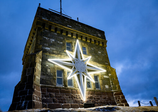 St. John's, Newfoundland, Canada-November 2024: The Signal Hill star designed by Kevin LaFleur on Cabot Tower, lights up the hill and City of St. John's at Christmas. The design is in a compass form. 