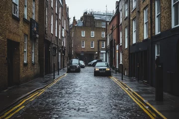 Fototapete Rund A narrow cobblestone street in London, England, with cars parked on either side. The street is wet from recent rain, and the buildings on either side are tall and narrow. © Abdul