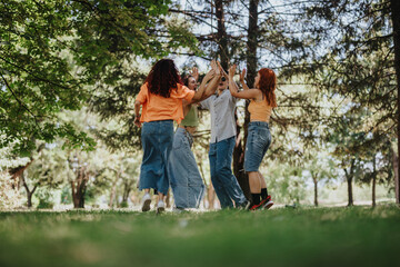 Fototapeta premium Young teenagers enjoying a playful moment in the park. The image captures friendship, joy, and laughter among the group.