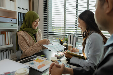 group of businessmen are discussing in an office. businessmen of different culture are meeting to make products that are appropriate and religiously correct. A businesswoman is wearing a hijab.