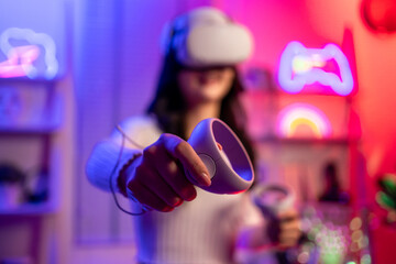 Asian young esport woman gamer use technology VR glasses and play game.