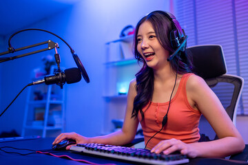 Portrait of Asian esport woman gamer play online video game on computer. © Pavitra