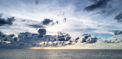 Sunset on sea. Ocean beach sunrise with calm cloudy sky.