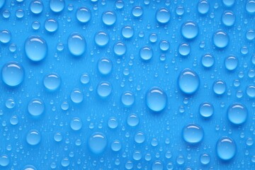 Water drops on blue background, top view