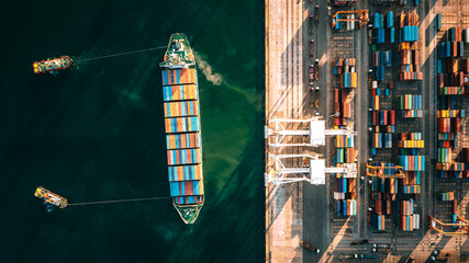 Top view of a large cargo ship loading and unloading containers at a deep sea port. Aerial view of international shipping and logistics hu