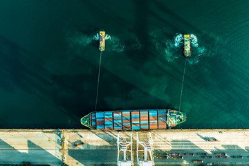 Top view of a large cargo ship loading and unloading containers at a deep sea port. Aerial view of international shipping and logistics hu