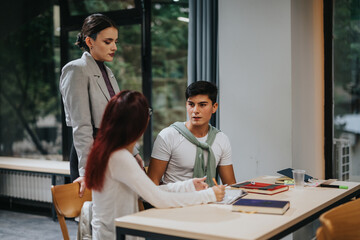 A group of students actively participates in a discussion at a classroom table, showcasing teamwork and learning in an academic environment. Bright and modern interior fosters focus and communication.