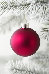 A vibrant red ornament dangles gracefully from a lush Christmas tree, shimmering against the backdrop of twinkling lights and festive decorations.