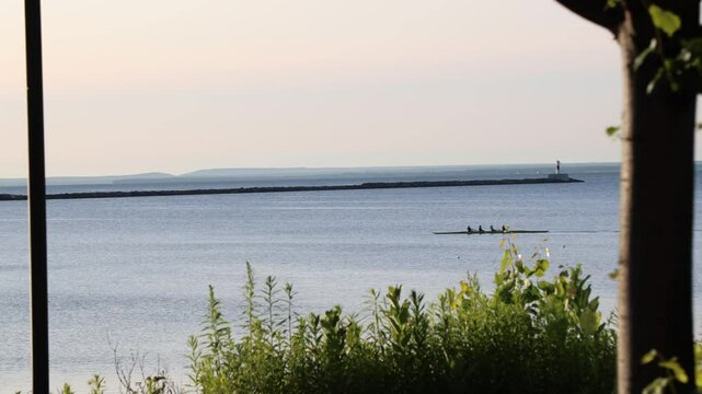 Rowing Team Sculls on Calm Grand River Channel Near Grand Haven Lighthouse at Dusk Michigan