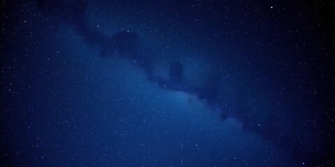 Fototapeta premium The Milky Way galaxy stretches across a dark blue sky, galaxy, planetary system, vastness
