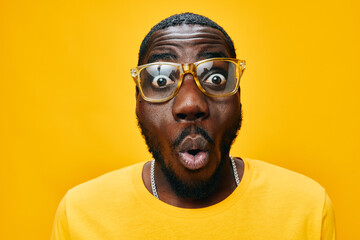 surprised man, vibrant yellow background, casual attire, facial expression of excitement and...