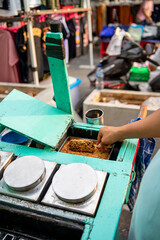 A seller adds peanut topping to Es Goyang. Es Goyang is a traditional ice cream made from coconut milk, granulated sugar and hunkwe flour which is sold using a wooden cart.