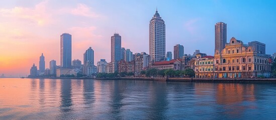 Naklejka premium A vibrant cityscape at sunrise with a mix of modern and historical architecture, reflected in the calm waters of the river.