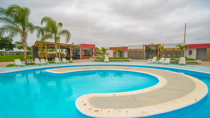 pisicina circular con mobiliario para visitantes en condominio
