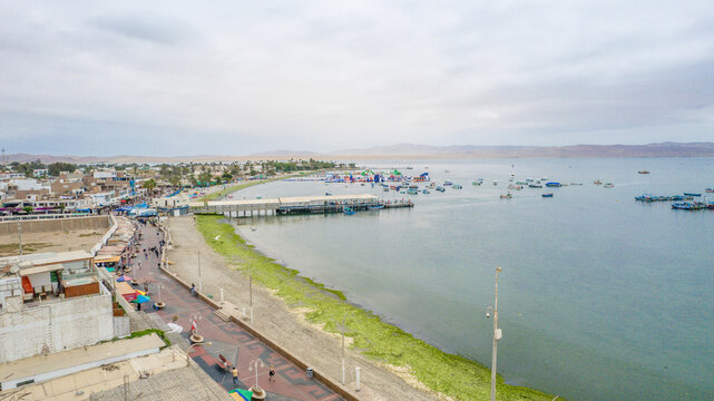 toma aerea con drone a balneario de paracas en peru, con vista al mar y botes pesqueros