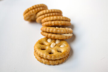 Row of sandwich biscuits filled with peanut butter flavored cream on a white background