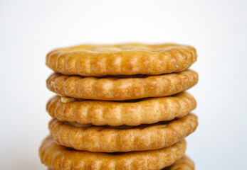 Stack of sandwich biscuits filled with peanut butter flavored cream on a white background