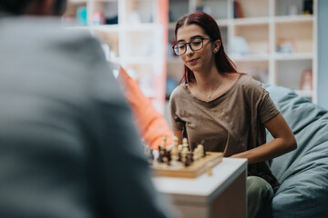 Two high school students engage in a friendly chess match, seated comfortably in a library setting. The scene conveys learning, strategy, and relaxation, fostered in an educational environment.
