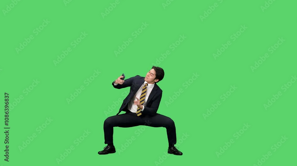 Poster スマホを使いながらダンスする男性ビジネスパーソンの全身動画　クロマキー合成用グリーンバック映像