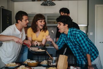 A group of friends share a joyful meal together in a kitchen setting, highlighting the essence of friendship, laughter, and shared moments over a delicious dining experience.