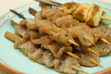 串に刺したコンニャクとネギを中華風の味付け