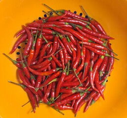 Pile of fresh red chili peppers in an orange bowl