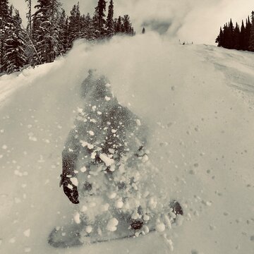 snowboarder flaking up snow
