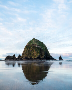 Sunrise at Cannon beach with reflection of Haystack Rock in Oregon
