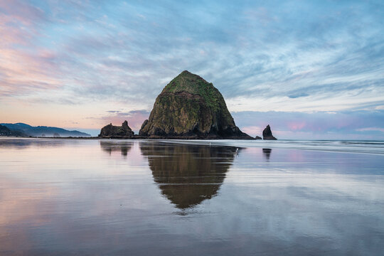 Sunrise at Cannon beach with reflection of Haystack Rock in Oregon
