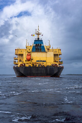 View of bulk carrier cargo vessels traveling on a cloudy day.