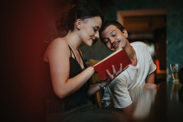 A couple enjoys a peaceful moment together reading a book in a warm, intimate setting. The relaxed ambiance suggests connection and happiness.