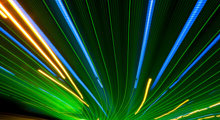 Green and blue light beams with golden streaks in a vibrant, abstract design