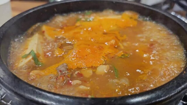 Soybean paste stew boiling in an earthen pot at a Korean restaurant