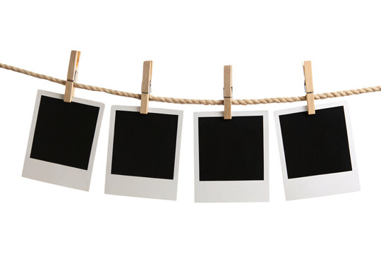 Four blank Polaroid photos clipped onto a rope with wooden pegs, evoking vintage vibes, ready to be filled with memories, set against a transparent background