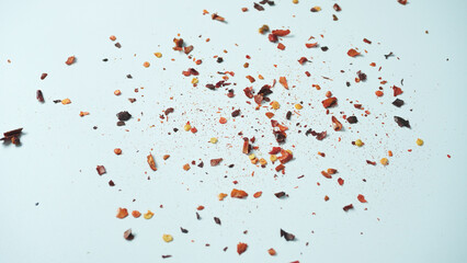 Crushed red cayenne pepper, dried chili flakes and seeds pile isolated on white background