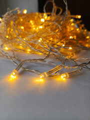 Bright burning garland diodes in close-up. Yellow lights of the LED garland on the table. The background for the advertisement, the place for the text.