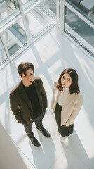 High angle shot of Asian man and woman in modern building, showcasing their perspectives