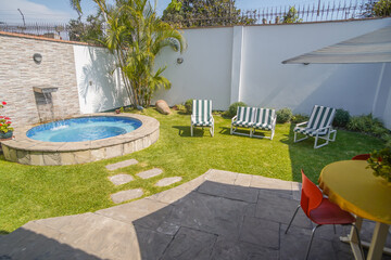 psicina en jardin interno de casa de campo con areas verdes y bancas para tomar el sol