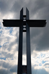 metal cross against the cloudy sky at the viewpoint in Żywiec