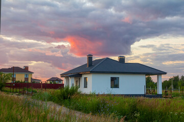 Obraz premium development of a new cottage village in the suburbs against the backdrop of a summer sunset