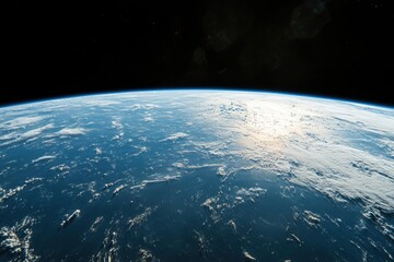Earth from space with sunlight reflecting off clouds.