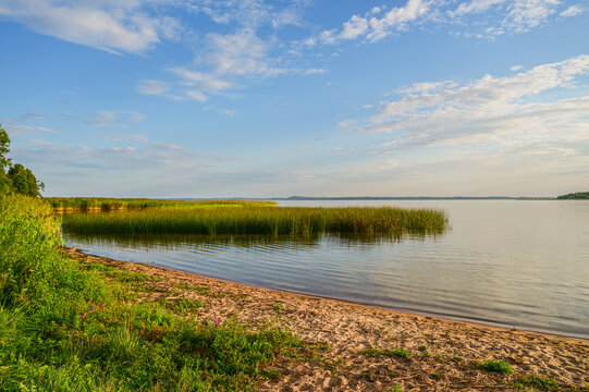 Beautiful evening atmosphere at sunset on the beach of Lake Razna, Raznas ezers, the largest lake in Latvia with panorama over the water, beach and forest in the background, Latgale, Latvia