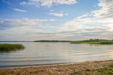 Beautiful evening atmosphere at sunset on the beach of Lake Razna, Raznas ezers, the largest lake in Latvia with panorama over the water, beach and forest in the background, Latgale, Latvia