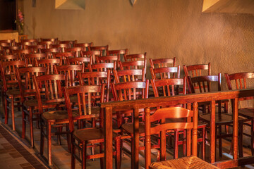 rows of old wooden chairs in a theatre or church