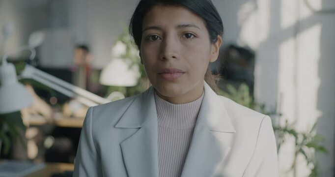 Slow motion portrait of Middle Eastern business lady in formalwear standing in coworking office looking at camera. Businesswoman and job concept.