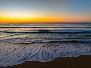 Sunrise at the seaside with clear skies and orange horizon