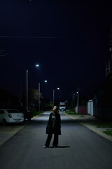Portrait of a teenage girl dressed in black clothes against the backdrop of a night city,...