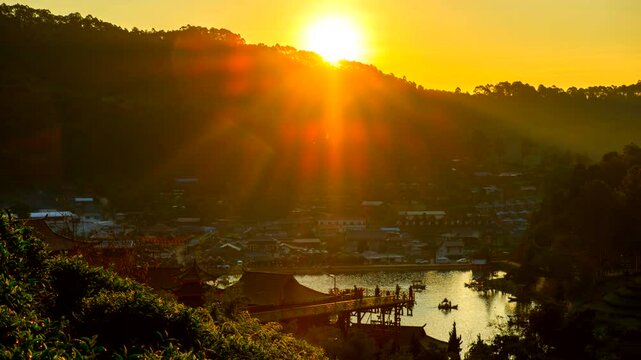 Time-lapse of sunrise in "Ban Rak Thai village" during the morning ambient beside a beautiful lake with antique boat. This village of Chinese settlement is a travel destination in Mae Hong Son provinc