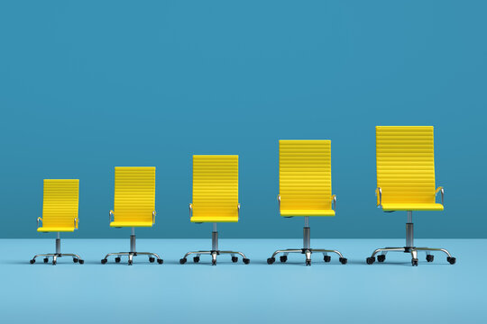 Row of yellow office chairs getting bigger showing career progression